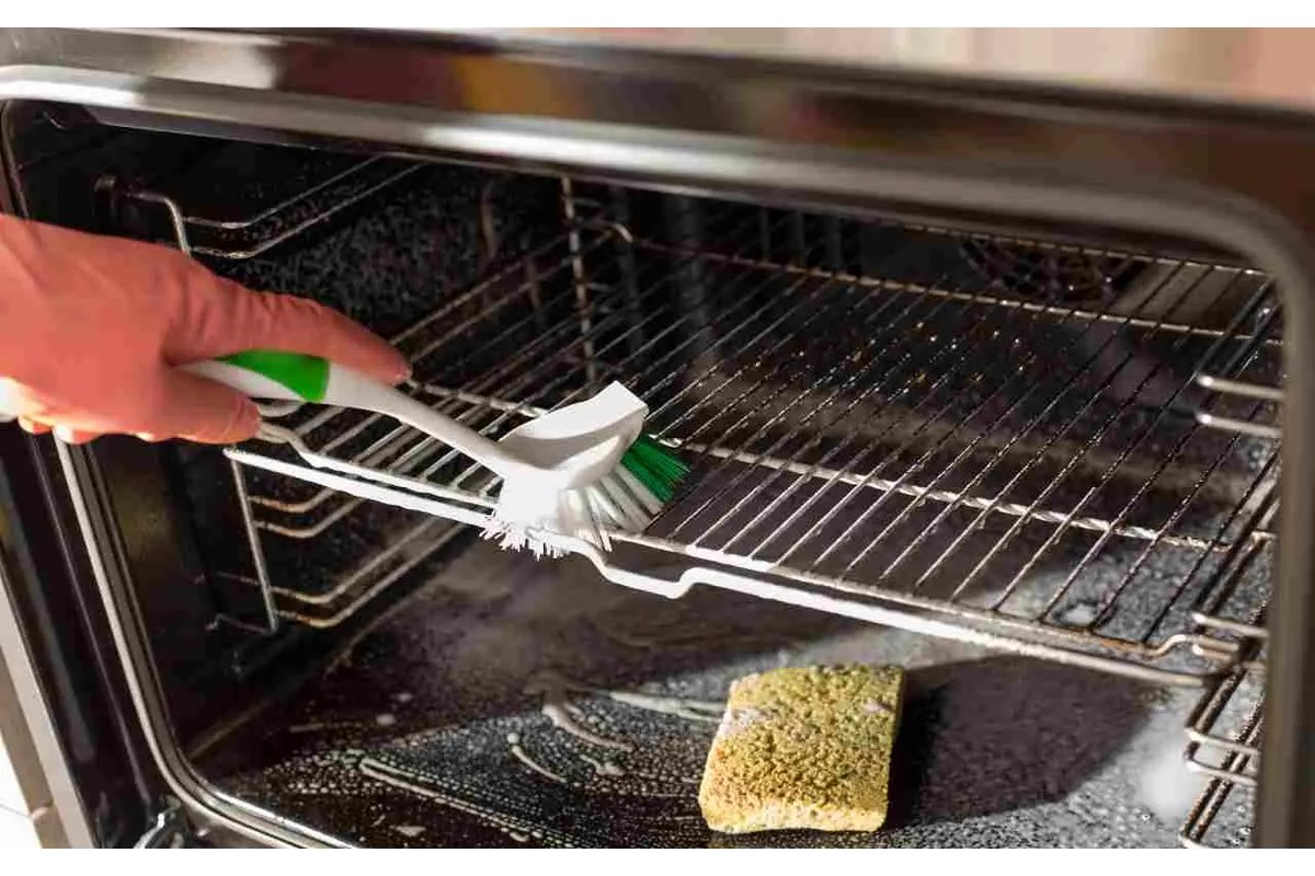 Spugna e detergente vicino a un forno aperto