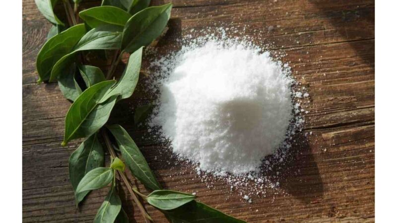 Foglie di alloro e bicarbonato su un tavolo di legno.