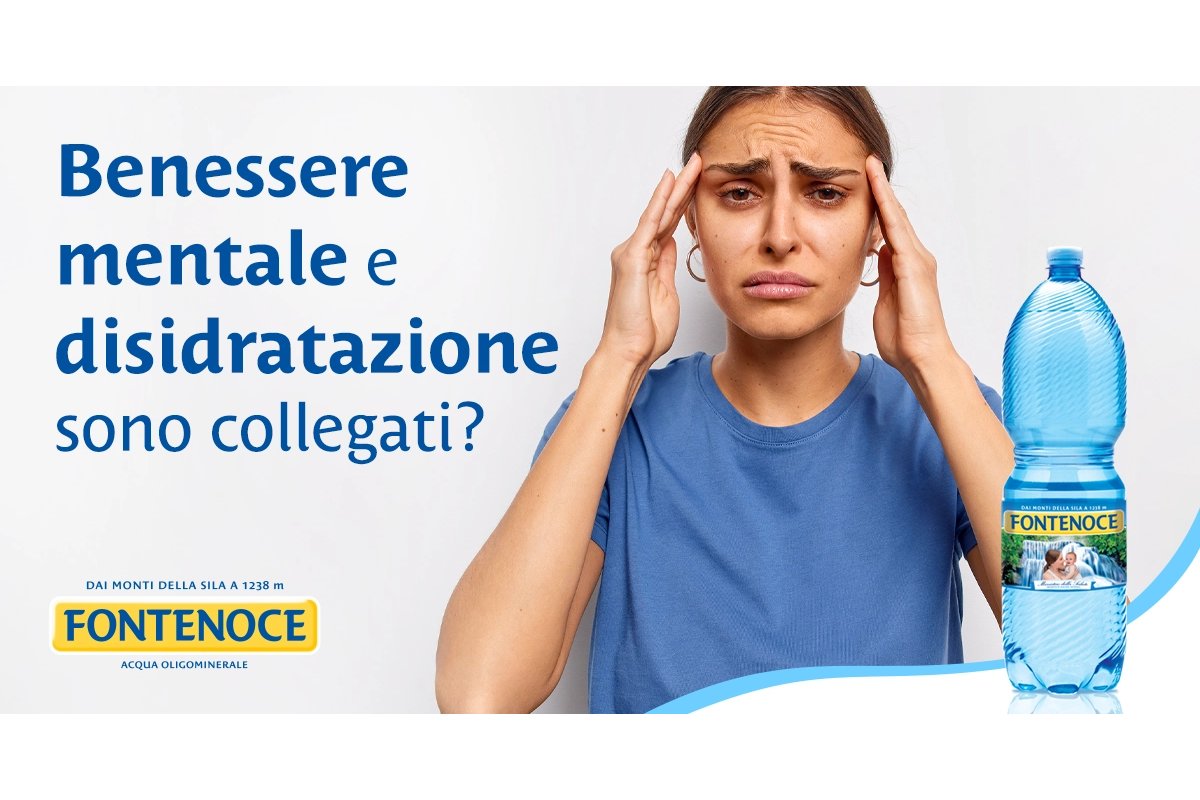 Persona che beve acqua durante una pausa lavorativa al computer.