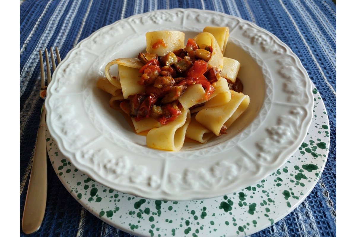 Pasta calamarata con melanzane dorate e basilico fresco.