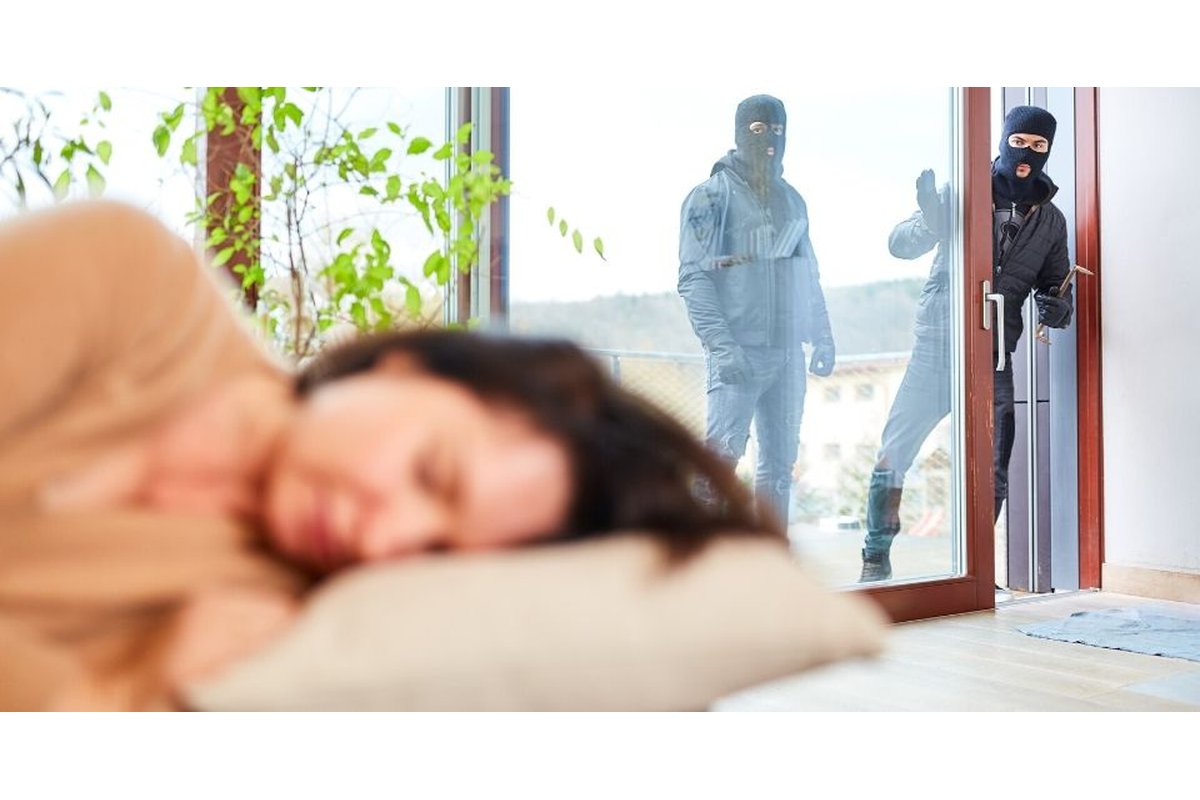 Ladro tenta di aprire una porta con strumenti da scasso.