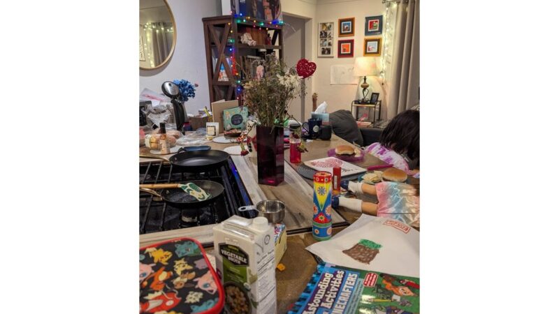 Scatole di stoccaggio colorate sotto un letto in una camera ordinata.