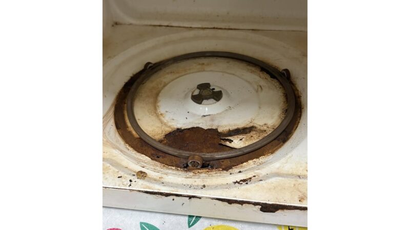 Microonde incrostato con una ciotola d'acqua all'interno.