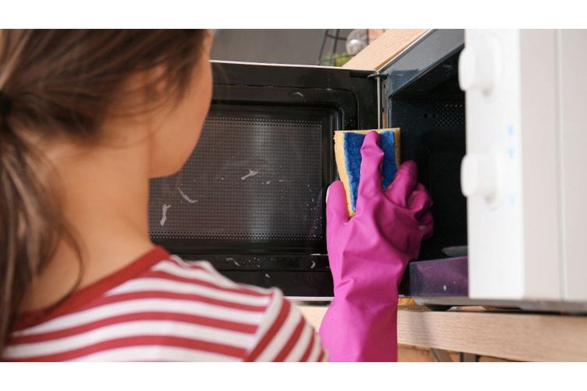 Interno di un microonde incrostato con una ciotola d'acqua calda.