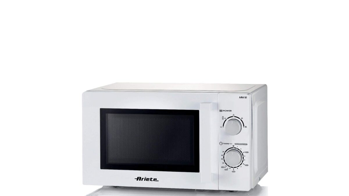 Persona che riscalda cibo nel microonde con un piatto coperto.