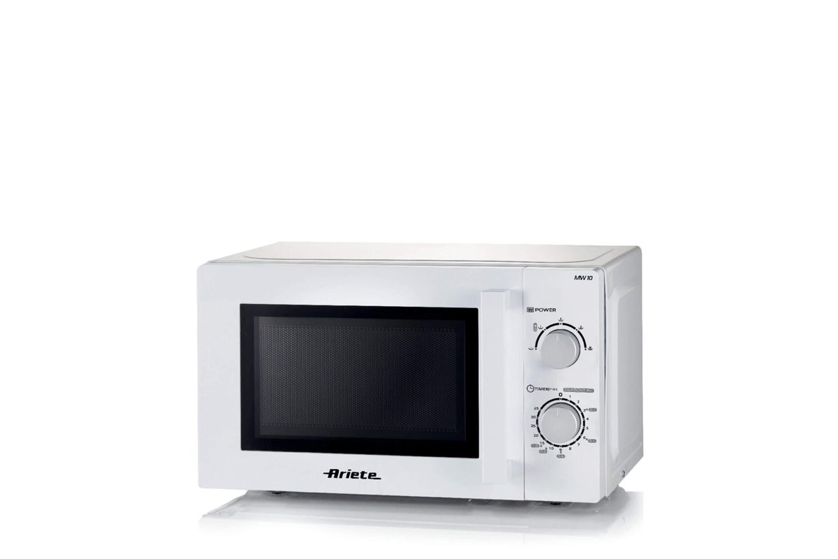 Persona che riscalda cibo nel microonde con un piatto coperto.