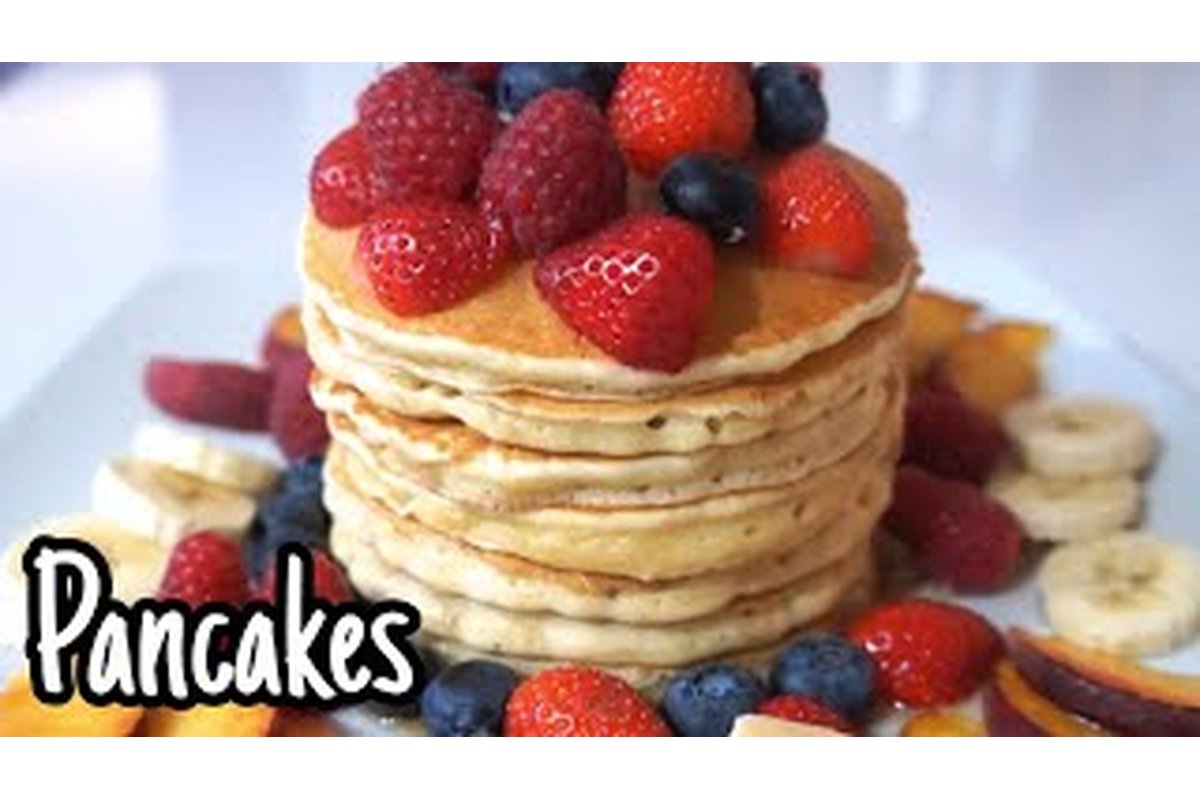 Pancake dorati impilati con ripieno cremoso e guarnizioni colorate