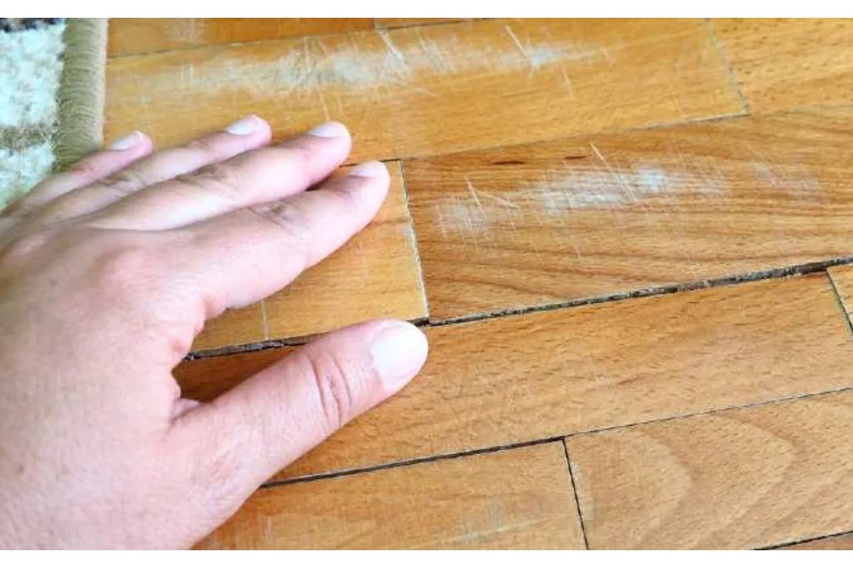 Donna che applica olio naturale su pavimento in parquet lucido.