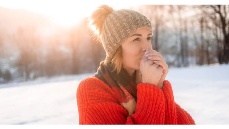 Persona che massaggia il ginocchio dolorante in un ambiente invernale