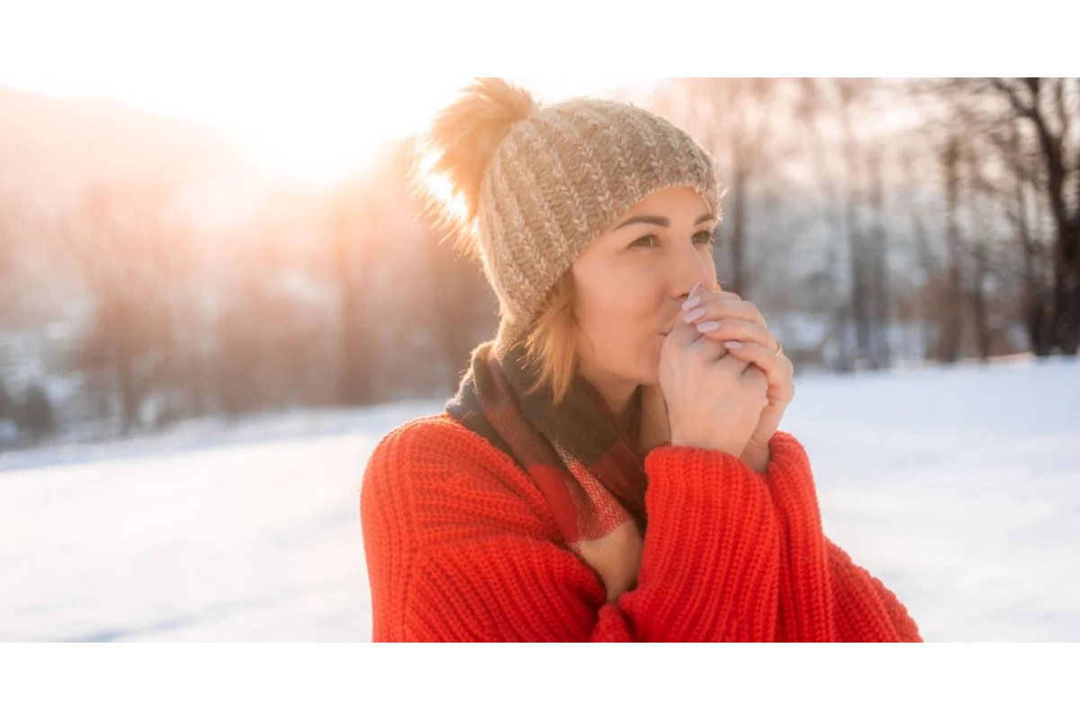 Persona che massaggia il ginocchio dolorante in un ambiente invernale