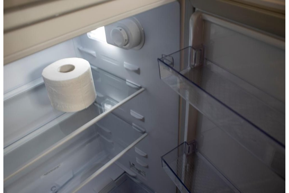 Rotolo di carta igienica posizionato su un ripiano del frigorifero.