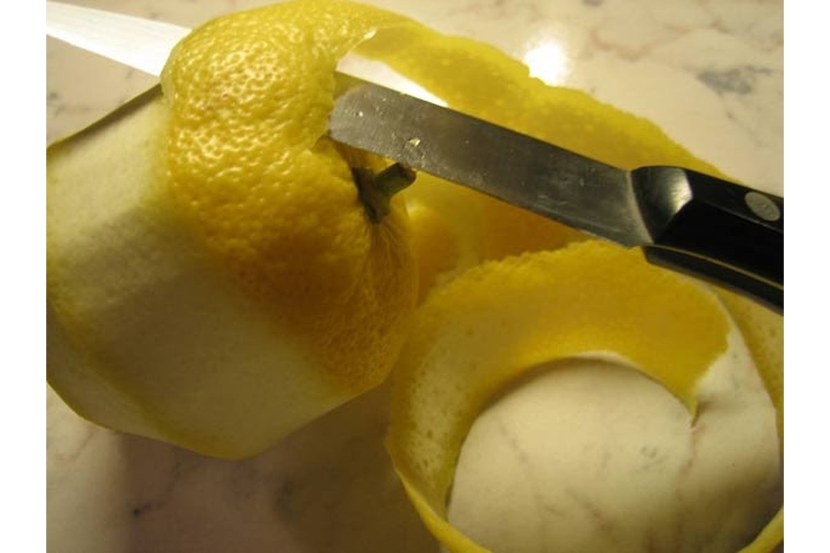 Bucce di limone e prezzemolo su un tagliere di legno.