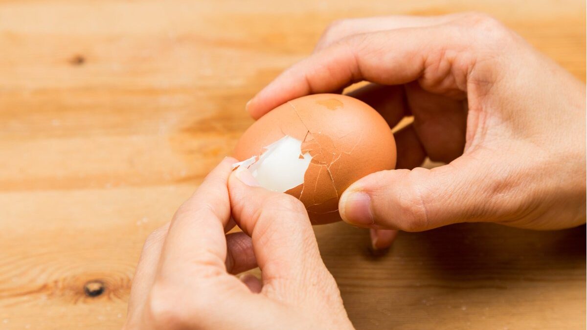 Uova sode con guscio parzialmente rimosso su un piatto bianco.