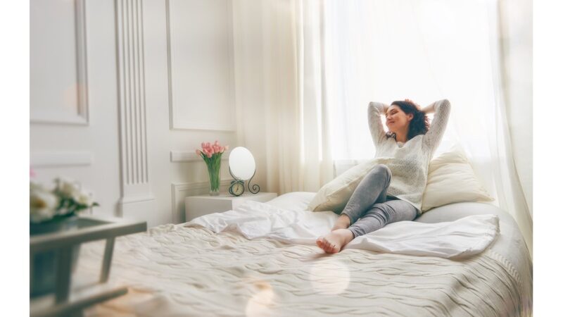 Camera da letto ordinata e pulita con letto rifatto e finestre aperte.