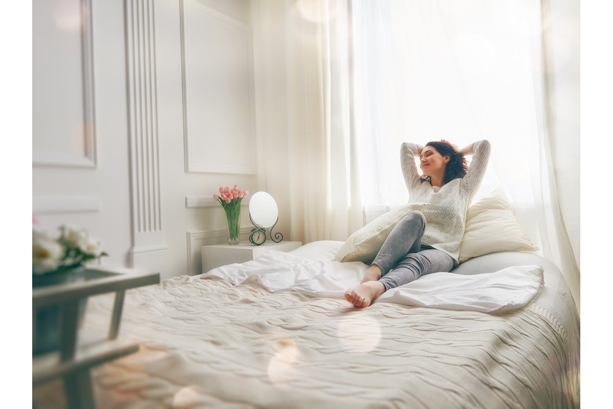 Camera da letto ordinata e pulita con letto rifatto e finestre aperte.