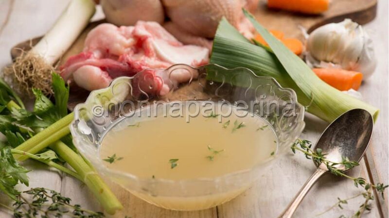 Ingredienti freschi per un brodo di pollo saporito su un tavolo di cucina.